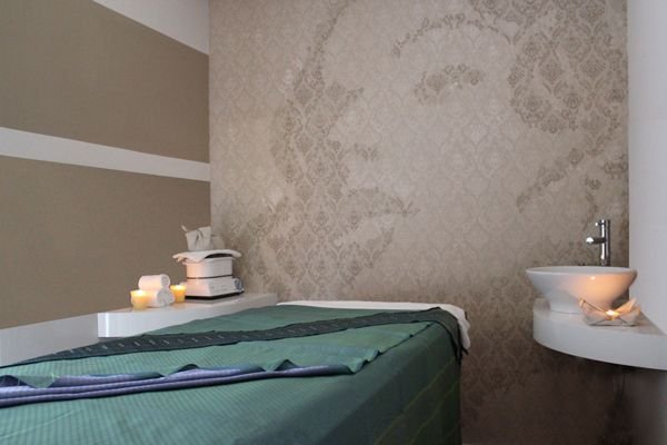 Una cabina di Estetica Carlucci con lettino, lavabo e asciugamani pronti per il trattamento