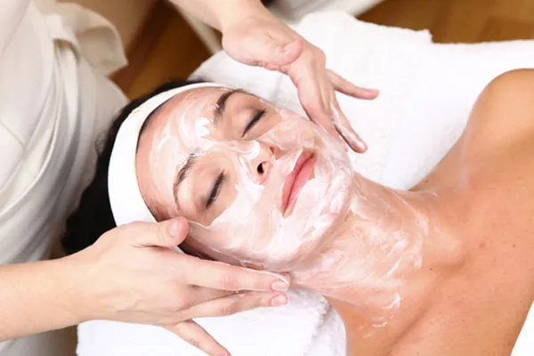 Estetista che applica una crema durante un trattamento viso in cabina